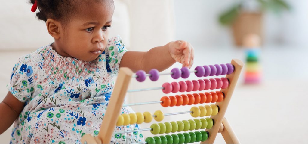 Black child playing with colorful toy.