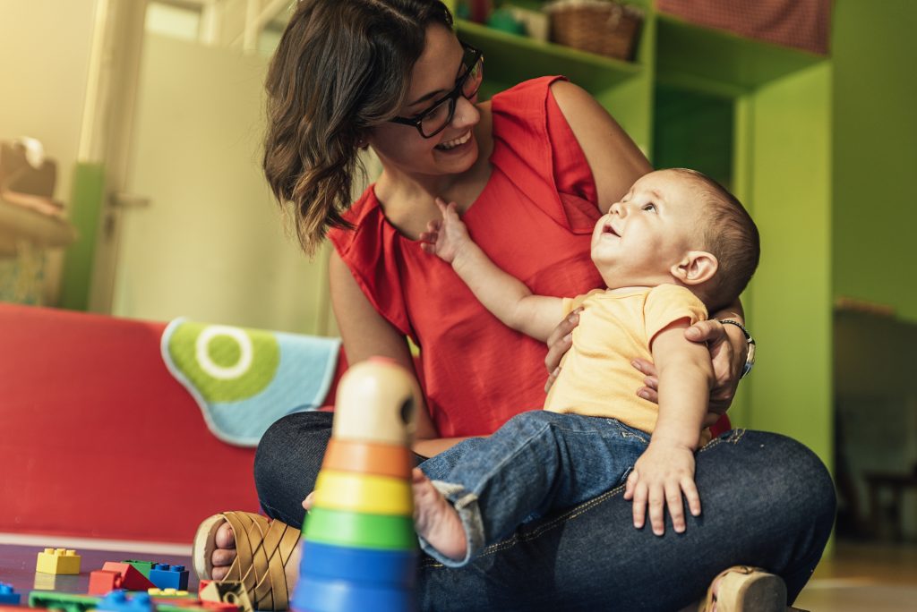 Female educator playing with child.