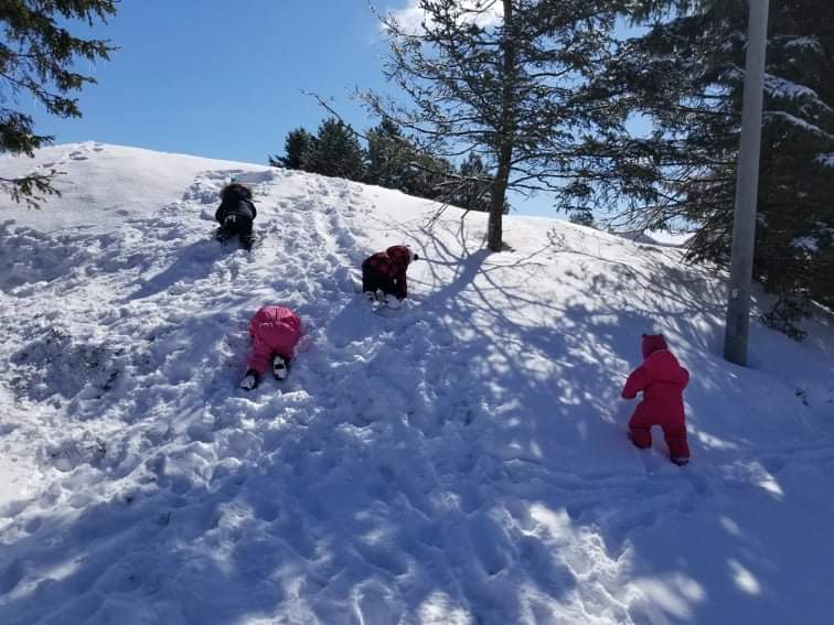 Children climbing snow mountain.