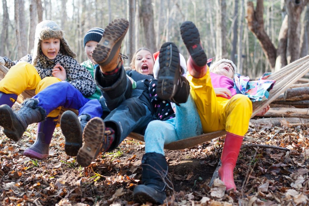 Enfants enjoués dans la forêt sur un hamac.