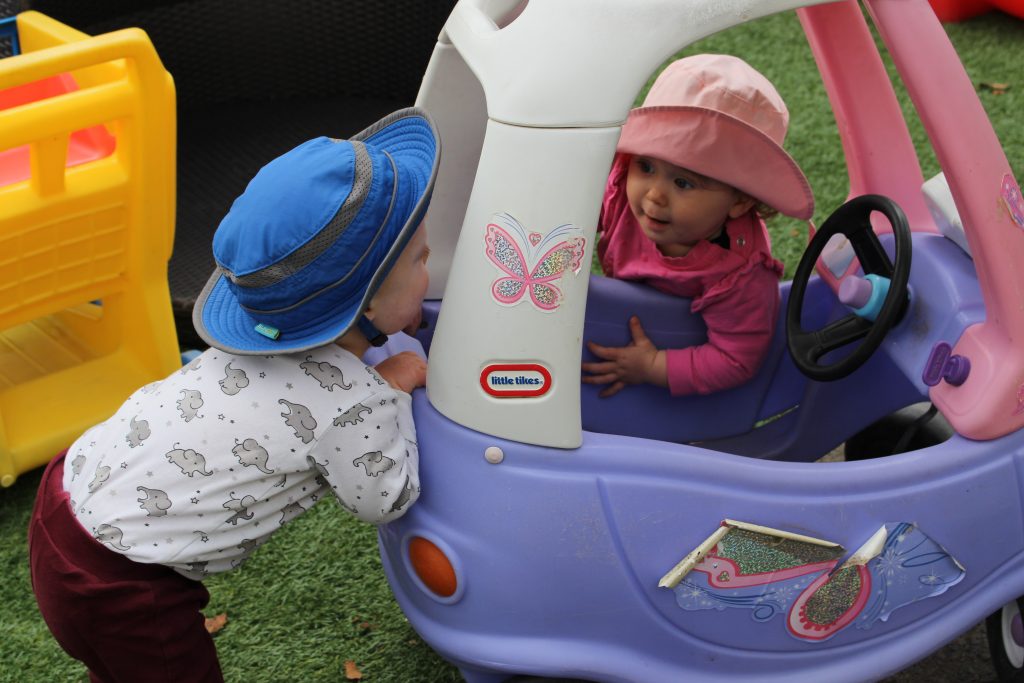 Toddler playing with toy car.