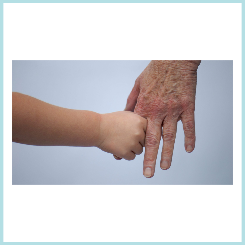 Enfant qui tient la main d'une personne agée.